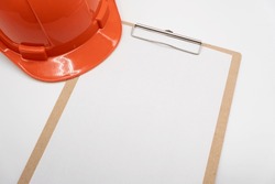 Blank clipboard paper and hard hat or safety helmet isolated on white background.
