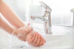 Woman use soap and washing hands rubbing with soap under the water tap. Hygiene new normal concept to stop spreading coronavirus or influenza virus in hospital or public wash room.