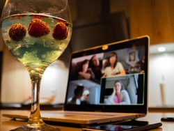 Having a cocktail with friends during a video call during the pandemic