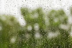 Raindrops on glass on a green background.Soft focus.Concept of sadness,bad mood.
