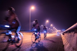 Blurry of Cyclists ride through lighted city