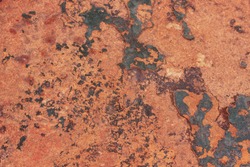 Stone surface. Redish rusty background with dark spots.