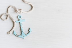 Sea background with anchor and marine rope on white wooden deck top view. Summertime sea background.