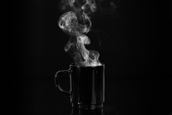 Cup of hot tea or coffee with steam from it in full black color