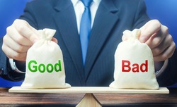 Businessman holds good and bad bags on scales. Evaluating the actions of other people, weighing the positive and negative qualities. Good and evil, karma. Introspection. Ethics and acceptability.