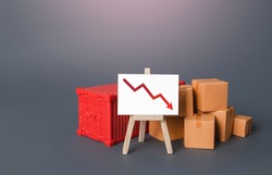 Boxes and container near the easel with a red down arrow. Drop of goods transportation volume, world trade traffic reduction. Decrease in industrial production. Fall in sales. Import and export.