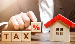 Man holds a percentage of real estate tax. Taxation on purchase or sale of a home. Maintenance of housing and land. Tax interest. Fees and duties. Rental business. Return on investment. Taxes relief