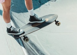 close-up detail of a girl balancing her skateboard before launching herself down a slope. skateboarding and fun concept. selective focus on the skateboard.