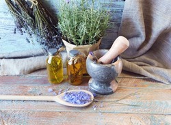 Useful plants, oils and tinctures, lavender flowers and rosemary in a pot, on a wooden background, natural ingredients, alternative medicine