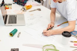 Fashion designer draws a sketch in the studio.  creative workplace for clothing production.