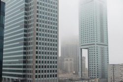 Beautiful modern metropolis in the fog with business and office buildings and the Palace of Culture in Warsaw. Amazing city of Warsaw, Poland on a cloudy, overcast day. Urban wallpaper 