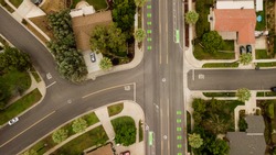 aerial drone view of a suburban neighborhood street and intersection