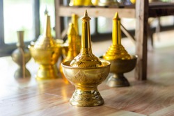 Selective focus of pour water brass with blurred background in temple. Traditional buddhist religious ceremony. Buddhism water libation culture belief after death