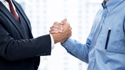 Business people shake hands when reaching a business agreement together.