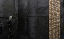 Rain shower in the bathroom. Dark granite walls, chrome plumbing, water.