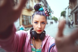 Cool funky young girl with headphones and crazy hair enjoy power of music taking selfie on street – hipster woman with trendy avant-garde look having fun - Music fan concept with playful carefree teen