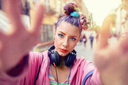Cool funky young rebel girl with headphones and crazy hair enjoy power of music taking selfie on street – hipster woman with trendy avant-garde look having fun - Music fan concept with carefree teen