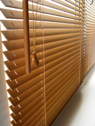 Wood blinds 25mm slats, venetian,  closeup on the window, beige color, white background. The natural wood.