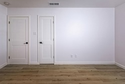 Empty bedroom with open doors leading to the livingroom, bathroom and a closet