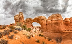 The famous Broken Arch in the Arches National Park, Utah and dramatic dark clouds