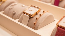 Beautiful fashion watch with leather strap and a gold bracelet in the shop window