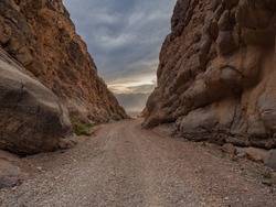 Narrow Canyon exit into vally with storm clouds
