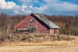 An antique horse-drawn cart in front of an old granary on the Saskatchewan prairies