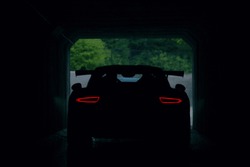 Silhouette of supercar in tunnel with stop lights. Rear view of supercar