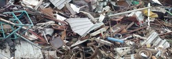 Panoramic view of pile of scrap rusty metal waste on recycling yard. Disposal and secondary metal recycling.