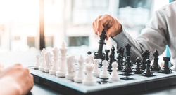 Business people are planning marketing strategies by analyzing the mechanisms and probability of the market by using chess to work, Playing chess for business concept.
