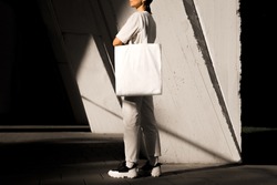Girl holding white tote bag, template can be used for your design