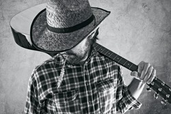 Western country cowboy musician with guitar, black and white portrait.