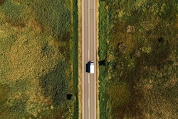 Aerial view of lorry truck on the road through countryside in sunny summer afternoon