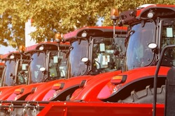Agricultural tractors aligned outdoor at farming fair, selective focus