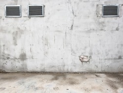 Worn cement wall with ventilation exhaust grills as urban background and copy space