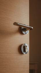 Modern metallic door handle on medium density fiberboard bedroom door, selective focus