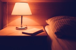 Book at night table in the bedroom, selective focus
