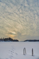 Finnish Tuusula lake in winter at sunset: cirrus clouds, nature of northern Europe, a lot of snow.