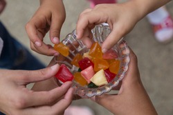 the child hold the colorful candies in the bowl service old humans for Muslim holidays, victim festival , mother or teacher day.