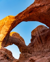 wide shot of two arches in the desert during sunrise