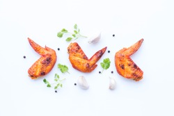 
Grilled chicken wings with vegetable and spices flat lay on white background, food ideas concept 
