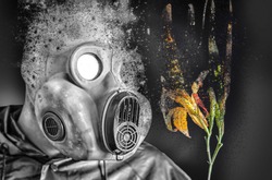 Man in the gas mask holding a burning flower. Radiation influence. Environmental pollution. Chernobyl concept. Dangerous nuclear power. Pollution concept.
