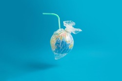 Ban plastic pollution. Globe wrapped in a plastic bag and a straw sticking out of the globe. Creative concept