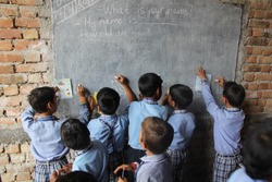 Children in rural indian village school learning to draw on the blackboard