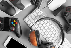 Gamepads, mice, headphones and keyboard on table