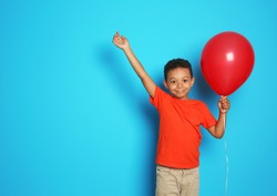 Cute African-American boy with balloon on color background. Birthday celebration