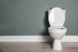 New ceramic toilet bowl near grey wall