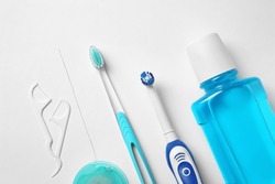 Flat lay composition with toothbrushes and oral hygiene products on white background