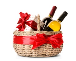 Festive basket with bottles of wine and gift on white background