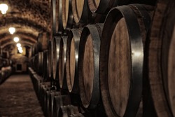 Wooden barrels with whiskey in dark cellar